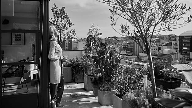 senior woman standing on garden balcony
