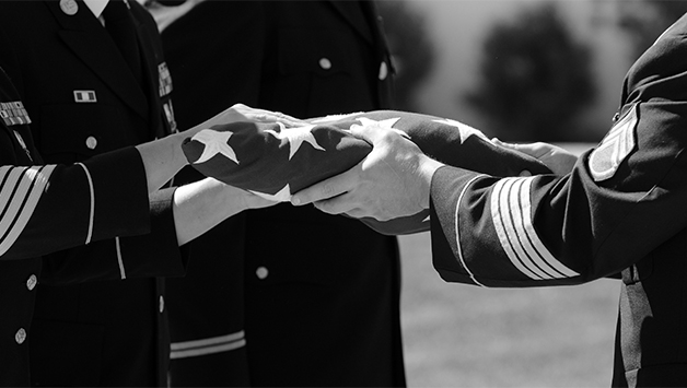 service members folding flag at funeral