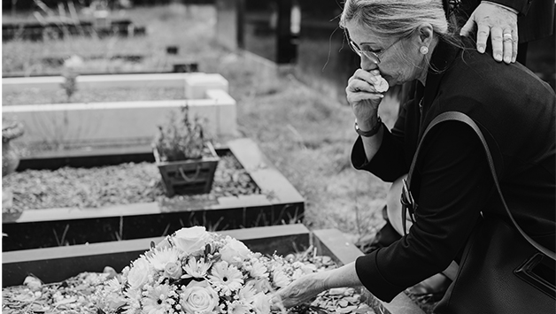 woman bending over grave site