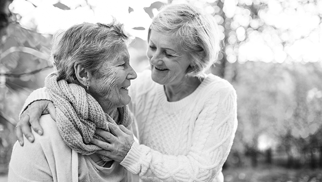 adult child with arms around senior mother