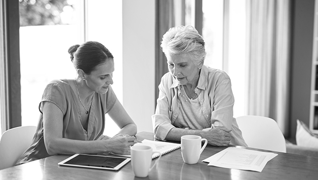 woman and daughter sitting at table planning senior care