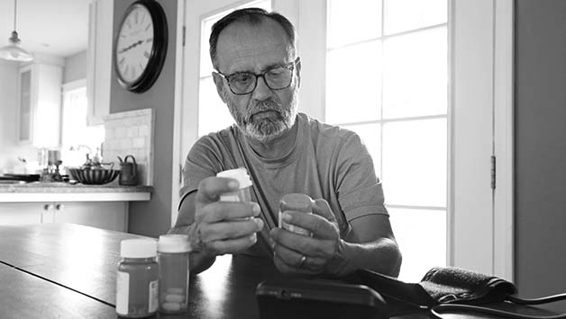 older man reading diabetes pills bottle