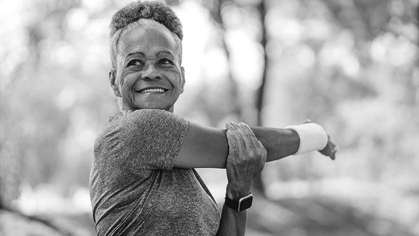 woman stretching arm outside