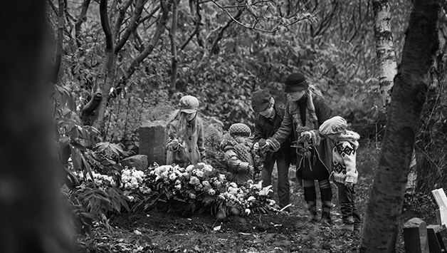 family at grave in forest