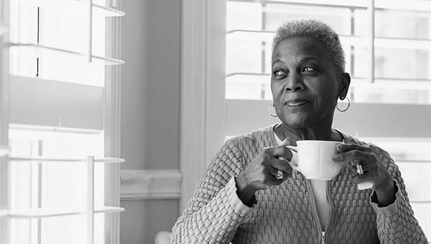 woman holding cup looking out window