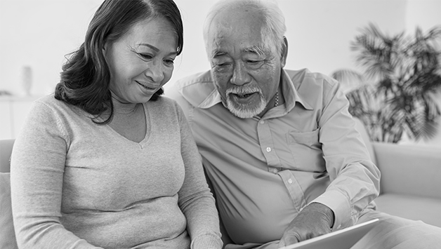 senior asian couple looking at a laptop