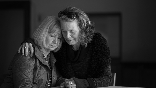 woman comforting woman at funeral