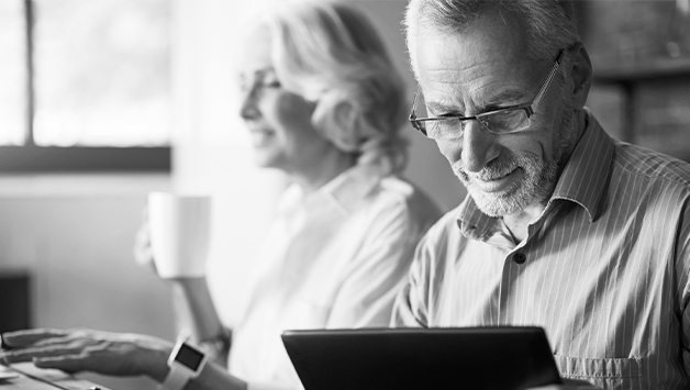 senior man reading insurance information on a tablet