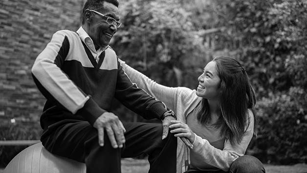 therapist helping senior man with therapy