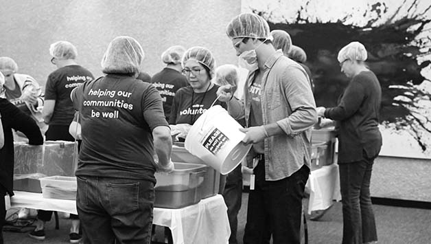 wellabe employees filling bags for charity